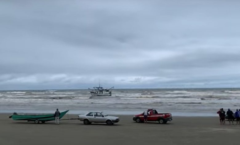 barco-de-pesca-encalha-em-praia-no-litoral-de-sp-e-quatro-pessoas-sao-regatadas;-video